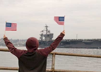 SAN DIEGO (Jan. 20, 2020) A young boy watches as Sailors man the rails aboard the Nimitz-class aircraft carrier USS Abraham Lincoln (CVN 72). Abraham Lincoln returns to Naval Air Station North Island after a 10-month deployment in support of maritime security operations and theater cooperation efforts in the U.S. 6th, 5th, and 7th Fleet area of operations. U.S. Navy photo by MC3 Nick Bauer