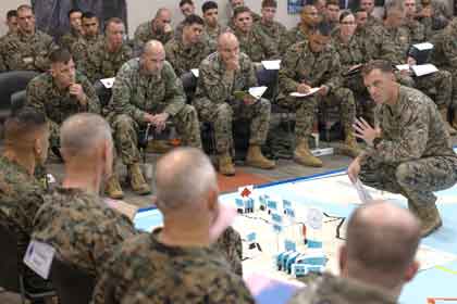 A U.S. Marine with I Marine Expeditionary Force briefs a rehersal of concept, off a terrain model, in preparation of Exercise Steel Knight 2025 on Marine Corps Base Marine Corps Base Camp Pendleton, California, Nov. 21, 2025. Steel Knight is an annual exercise that strengthens the Navy-Marine Corps team's ability to respond forward, integrate across domains, and sustain Marine Air-Ground Task Force readiness. U.S. Marine Corps photo illustration by Lance Cpl. Ricardo Del Castillo. This photo was altered due to security purposes.
